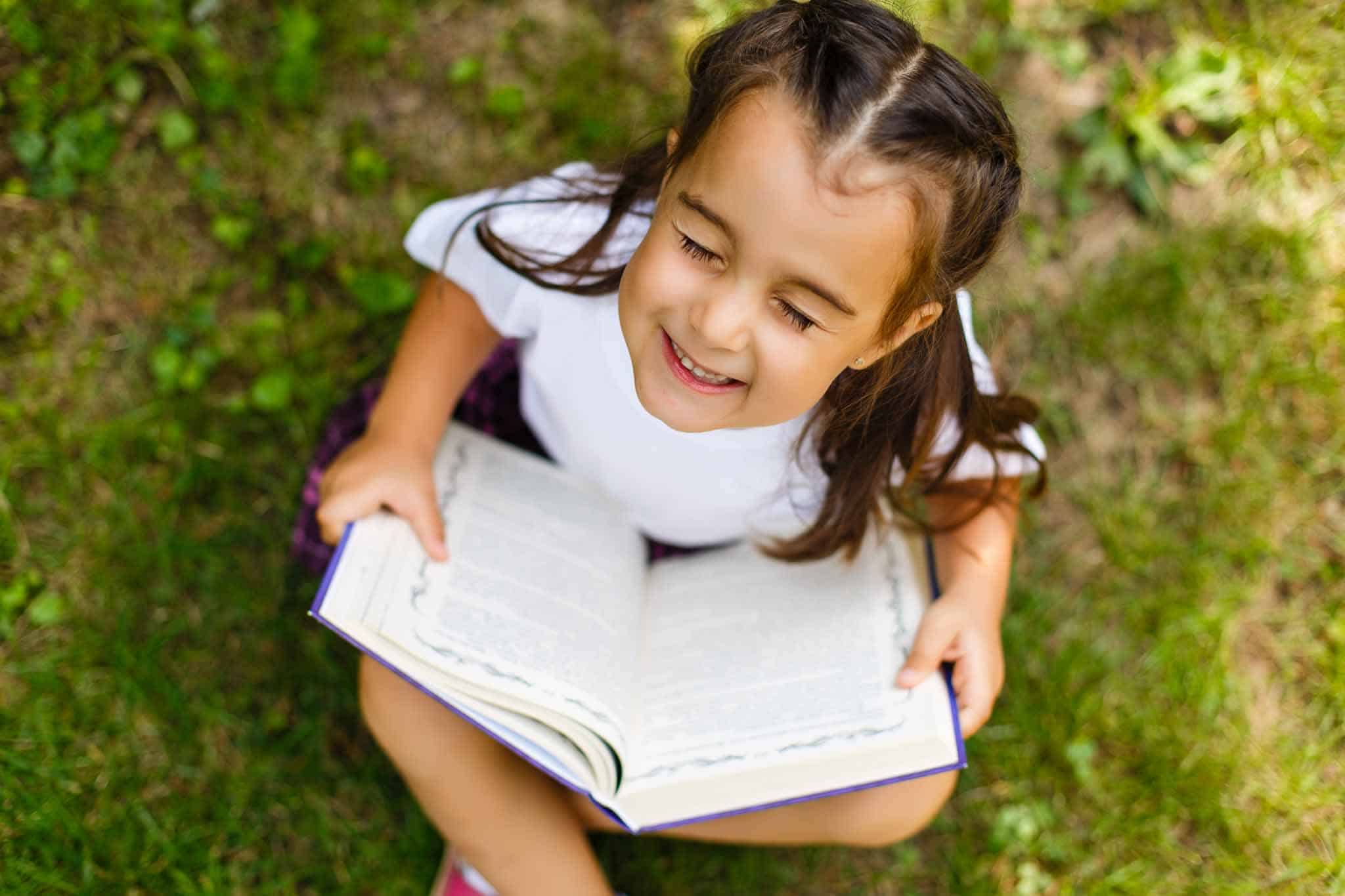 Girl joyful reading an inspirational book. 