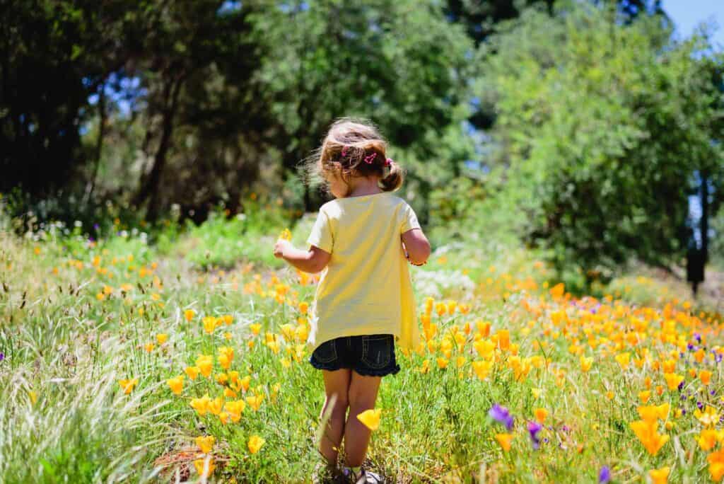 Girl walking through a field of flowers. 