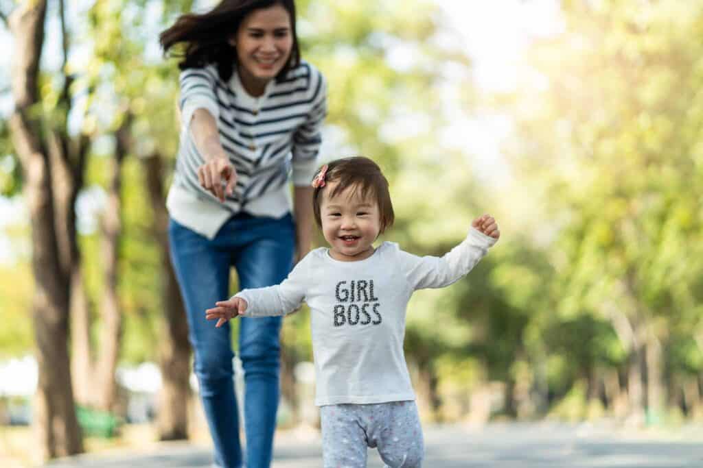 Mom chasing after young girl with a shirt that says "girl boss."
